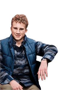 a young man in a blue vest sitting on a chair